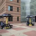 Appalachian students pause between classes to charge their phones at the three new solar-powered picnic tables available on the first-floor patio of Peacock Hall. Photo by Marie Freeman
