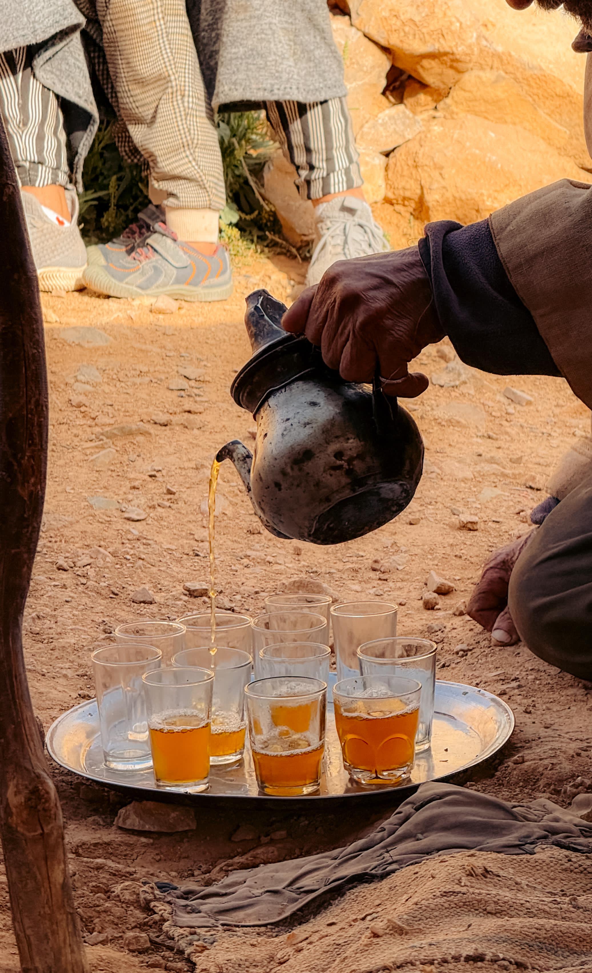 This image shows an older gentleman pouring tea in Morocco.