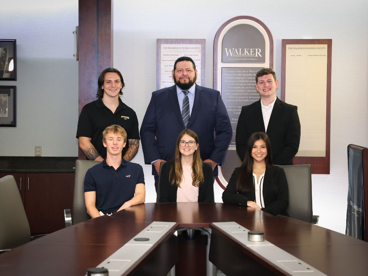 Victor Salgado is pictured, center, with fellow executive impact club officers around a boardroom table