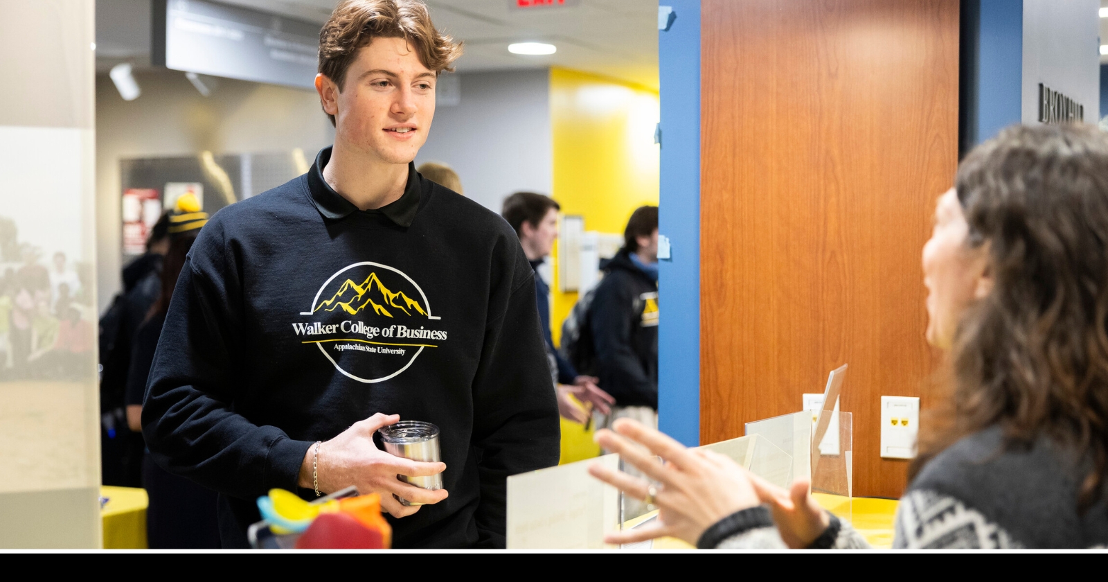 A student in Peacock Hall speaks with a faculty member