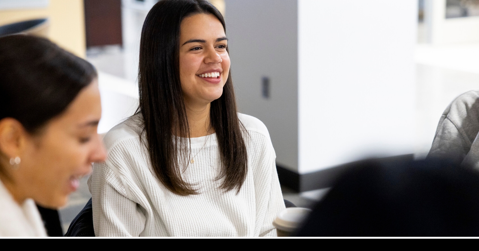Student in Peacock Hall, laughing with peers