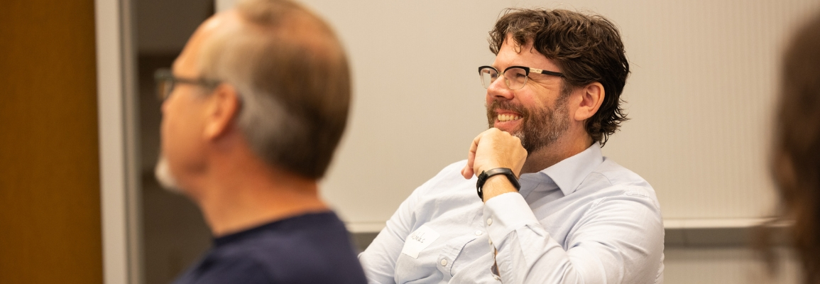 Nick Poggioli sits in the audience of a session during the Global Good Conference