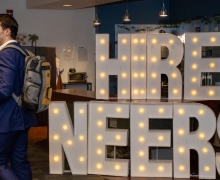 An App State student in front of "HIRE NEERS" sign