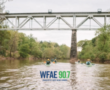 A group of kayakers travel on the South Fork River.