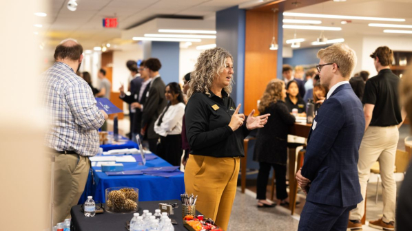 A banking professional speaks with students during Bank Day in Peacock Hall, helping connect future business leaders with industry opportunities. Photo by Chase Reynolds