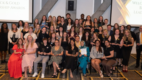 Dozens of recipients of App State Black and Gold Awards smiling at the awards ceremony
