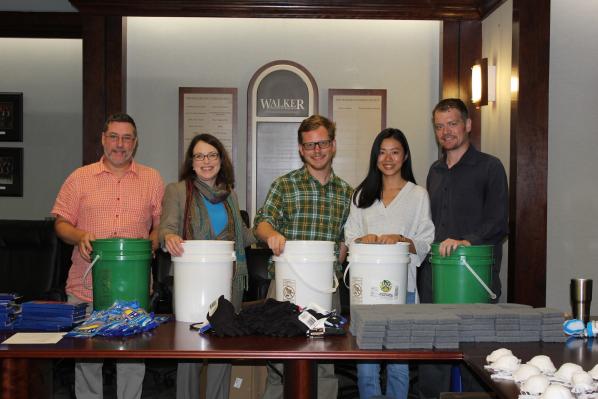 Walker College of Business Dean Norris, second from left, with AppState Executive Impact Club members Tim Walker, Logan Edwards, Teea Wan and Wade Hampton assemble flood buckets for hurricane relief.