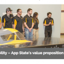 Chancellor Sheri N. Everts admires Appalachian State University's solar vehicle, Apperion, and its 2017 display of sponsors at an unveiling in early April. Some members of Team Sunergy look on. Photo by Marie Freeman