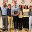 App State students stand in front of the BAP banner, holding a plaque indicating their Platinum status