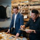 Appalachian alumni Bradley Rhyne ’07, left, and Filipe Ho ’07 review fabric swatches at their OLE MASON JAR menswear shop in Charlotte. Photo submitted