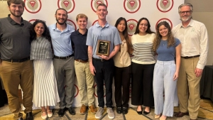 App State students stand in front of the BAP banner, holding a plaque indicating their Platinum status