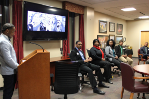 Jonavan Adams, seated on the right, responds to a question posed by Jalen Sanders, left, the emcee of a panel discussion, “Courageous Conversations.”  The Walker College of Business collaborated early in February with Kappa Alpha Psi fraternity to hold a panel discussion, in observance of Black History Month. Seated beside Adams are fellow panelists Ramona Harris,’16, Kacey Griffin 13, and current MBA student, Patrick Preudhomme.