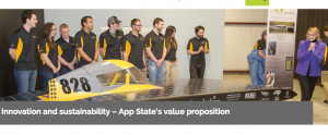 Chancellor Sheri N. Everts admires Appalachian State University's solar vehicle, Apperion, and its 2017 display of sponsors at an unveiling in early April. Some members of Team Sunergy look on. Photo by Marie Freeman