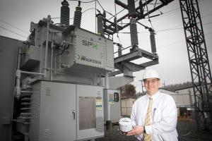 Data gathering: NRLP General Manager Ed Miller is holding an Advanced Metering Infrastructure (AMI) device which, when installed at the customer site, will enable measurement of detailed, time-based information and frequent collection and transmittal of such information to the supplier.